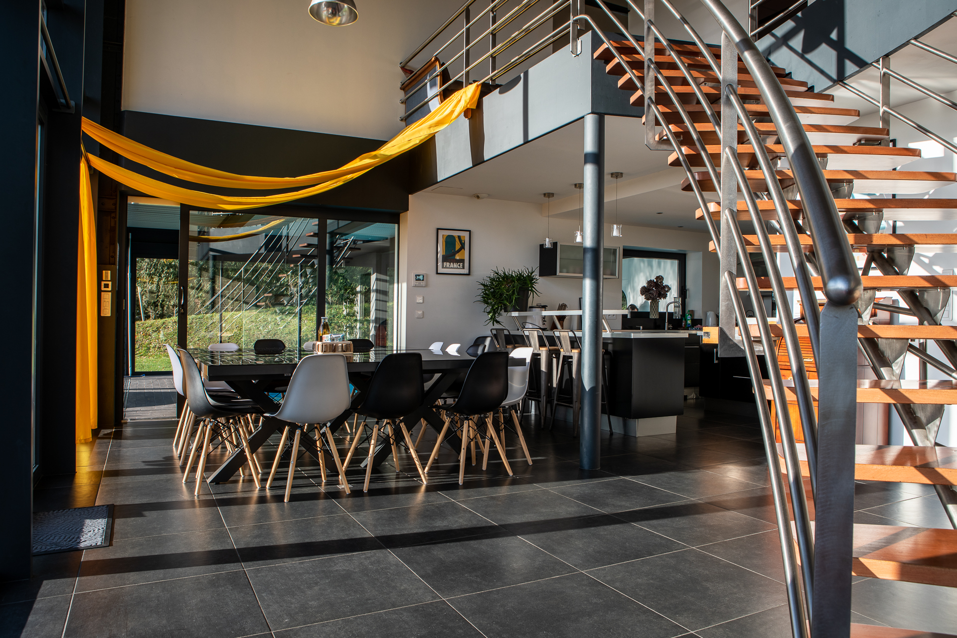 Salle à manger et espace de vie sous la mezzanine, escaliers en acier et bois